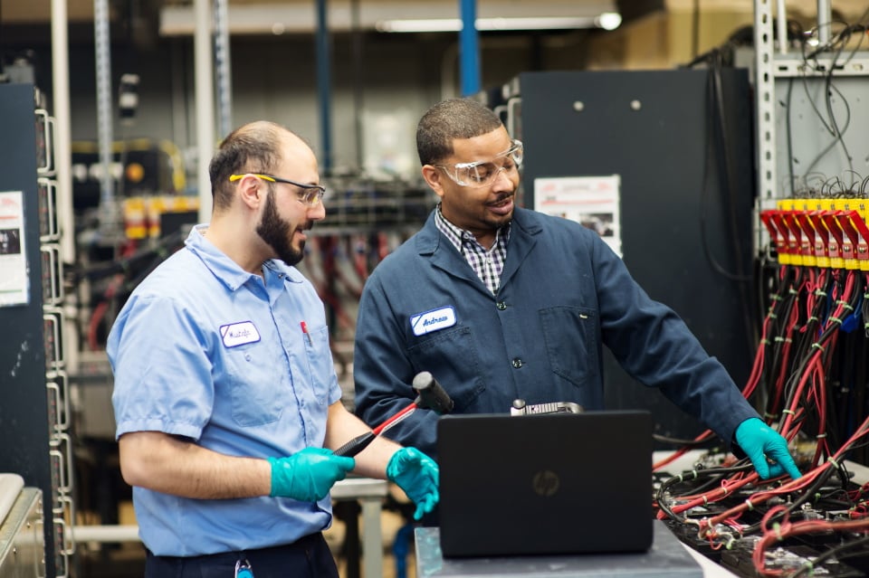 two-male-plant-employees-checking-wiring