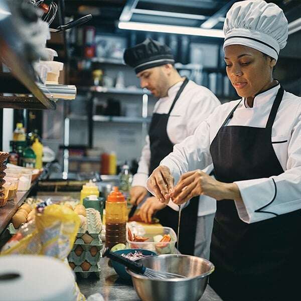 chef-cracking-an-egg-while-preparing-food-in-restaurant